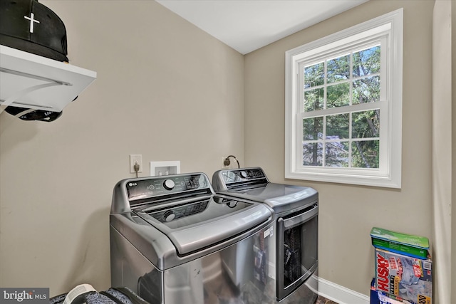 clothes washing area with laundry area, independent washer and dryer, and baseboards