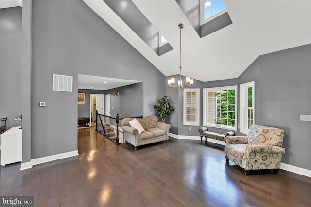 living area featuring a skylight, baseboards, visible vents, wood finished floors, and an inviting chandelier