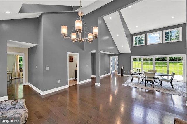 dining area with a high ceiling, wood finished floors, and baseboards