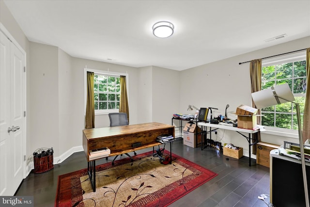 office area featuring a healthy amount of sunlight, visible vents, baseboards, and dark wood-style flooring