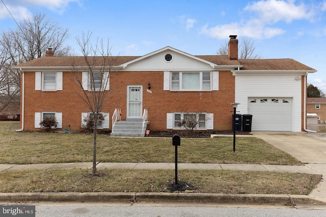 raised ranch featuring a front yard, brick siding, driveway, and a chimney