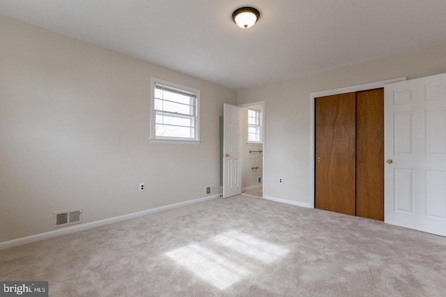 unfurnished bedroom with baseboards, carpet, visible vents, and a closet