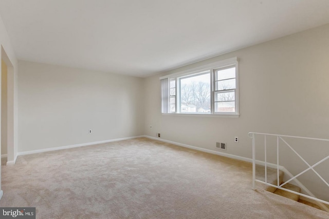 carpeted spare room with baseboards and visible vents