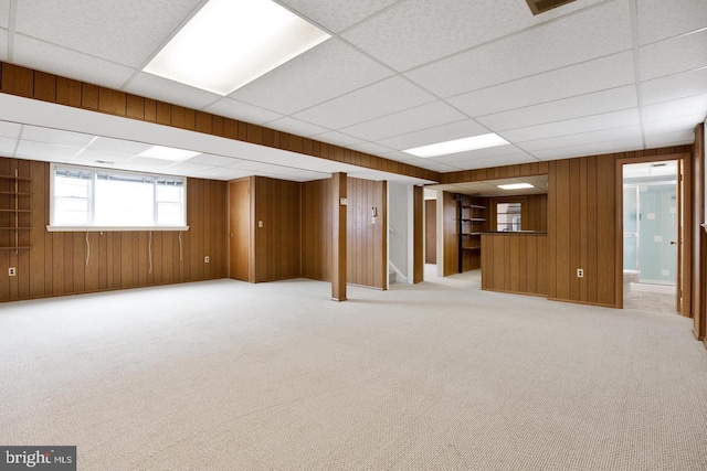 basement featuring carpet and wood walls