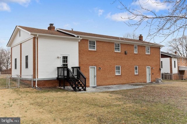 rear view of property with a chimney, a patio area, and fence