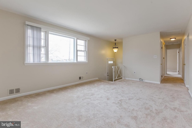 carpeted spare room featuring visible vents and baseboards