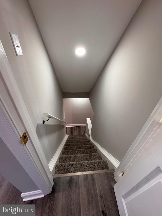 stairway with baseboards and wood finished floors