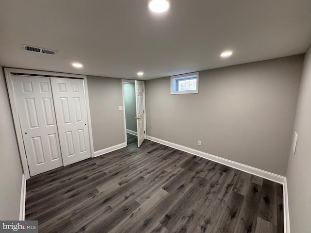 basement featuring baseboards, visible vents, dark wood finished floors, and recessed lighting