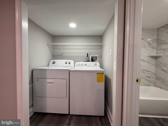 clothes washing area featuring laundry area, separate washer and dryer, and dark wood-style flooring