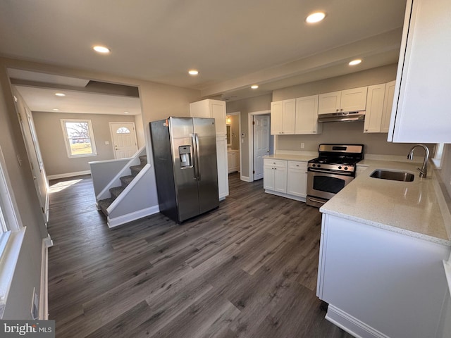 kitchen featuring dark wood-style floors, appliances with stainless steel finishes, white cabinets, a sink, and under cabinet range hood