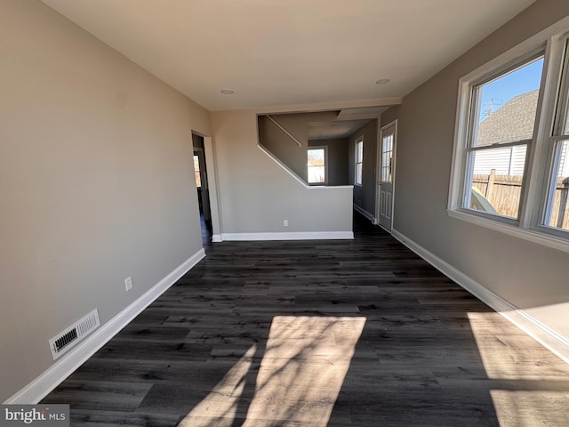 interior space featuring baseboards, visible vents, and dark wood-type flooring