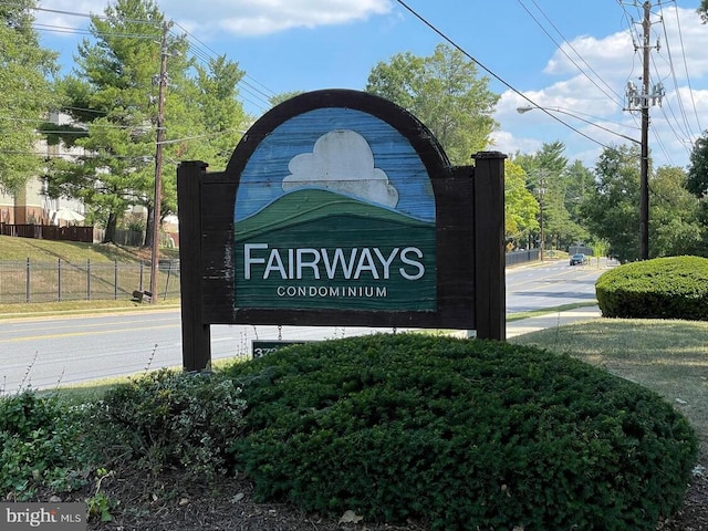 community / neighborhood sign featuring fence