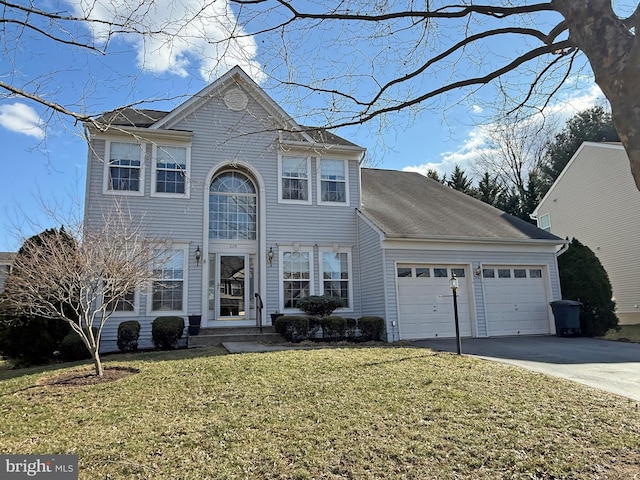 traditional home featuring a front lawn, an attached garage, and driveway