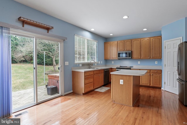 kitchen featuring visible vents, light wood-style flooring, a sink, light countertops, and appliances with stainless steel finishes