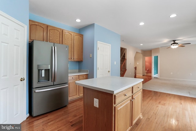 kitchen with light countertops, light wood-style flooring, a ceiling fan, and stainless steel fridge