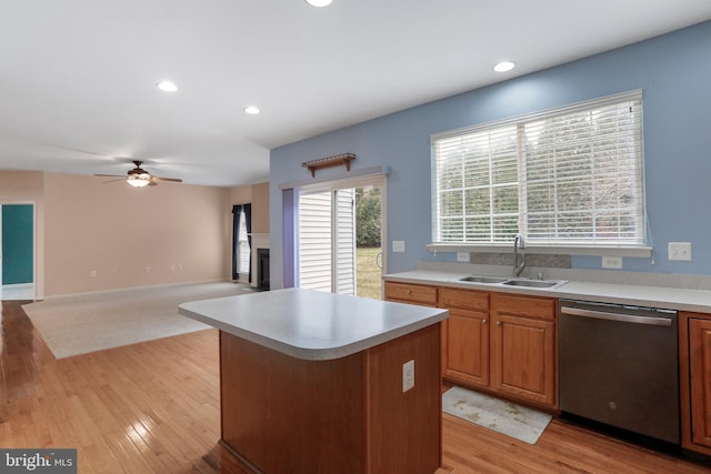 kitchen with a sink, light countertops, ceiling fan, and stainless steel dishwasher