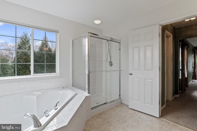 bathroom with tile patterned floors, a bath, and a shower stall