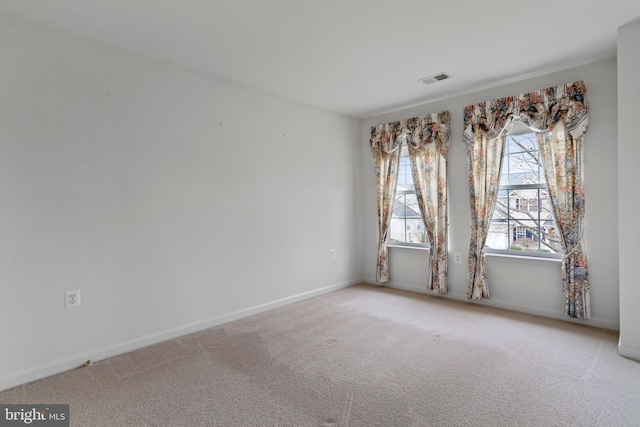 carpeted empty room featuring visible vents and baseboards