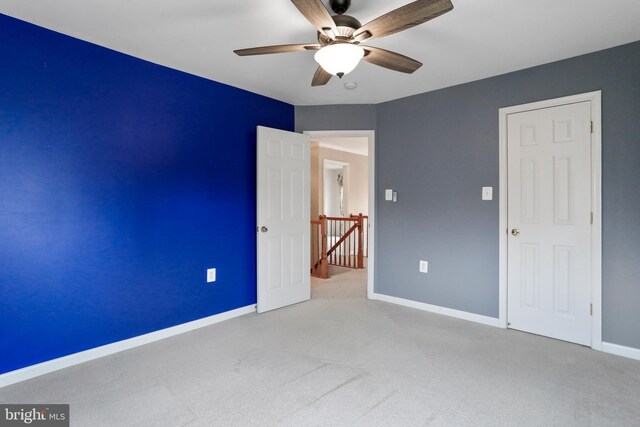 unfurnished bedroom featuring carpet flooring, a ceiling fan, and baseboards