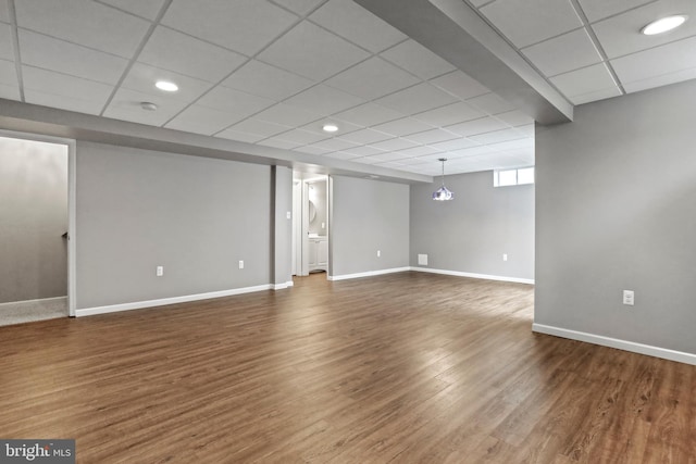 basement featuring recessed lighting, a drop ceiling, baseboards, and dark wood-style flooring