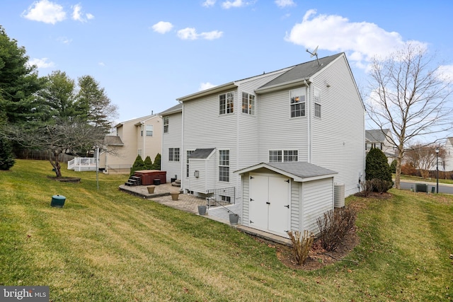 rear view of house with a lawn and a hot tub