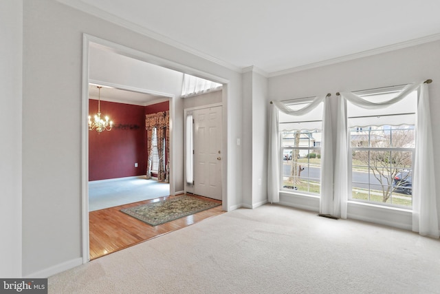 carpeted entrance foyer with a notable chandelier, crown molding, and baseboards