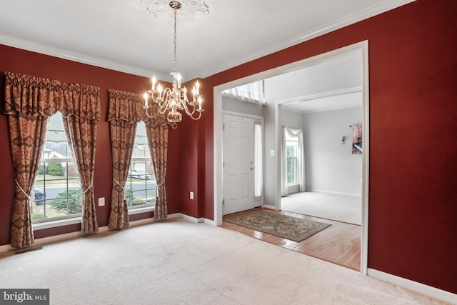 carpeted foyer entrance featuring wood finished floors, baseboards, visible vents, ornamental molding, and a notable chandelier