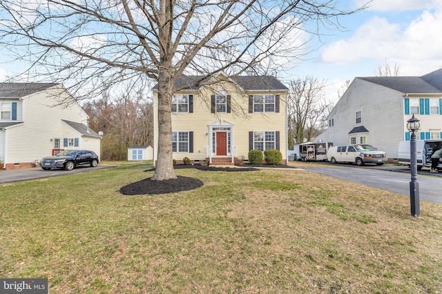 colonial-style house featuring crawl space and a front lawn