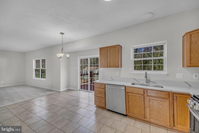 kitchen featuring a wealth of natural light, stainless steel appliances, light countertops, and a sink