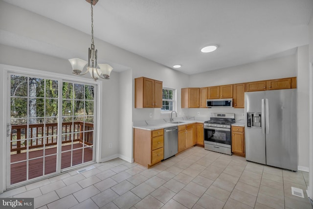 kitchen featuring pendant lighting, a sink, stainless steel appliances, light countertops, and light tile patterned floors