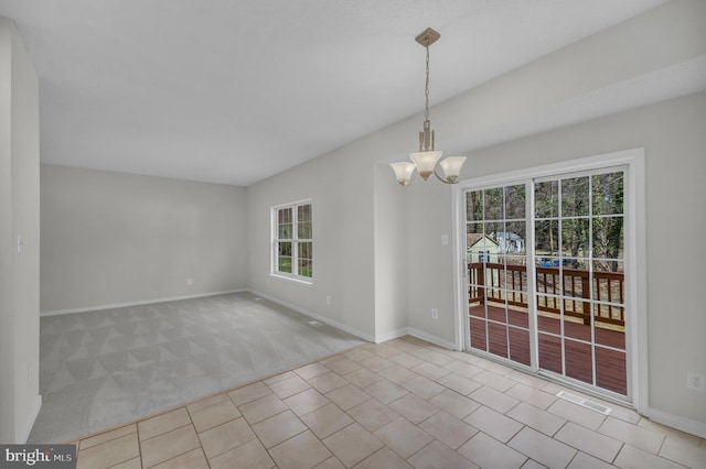 unfurnished dining area featuring baseboards, carpet floors, a notable chandelier, and visible vents