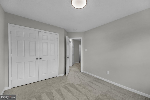 unfurnished bedroom with a closet, baseboards, and carpet floors