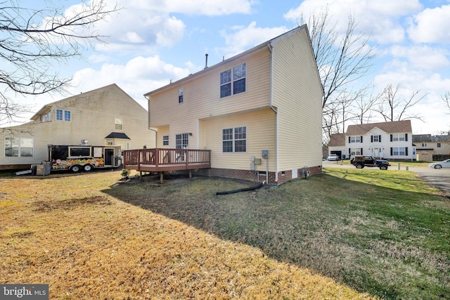 rear view of property with a deck, a lawn, and crawl space