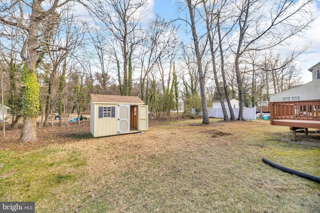 view of yard with a deck, an outbuilding, and a storage unit