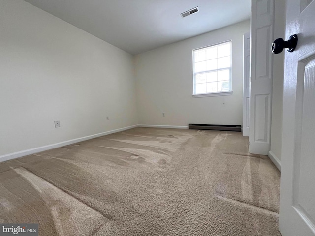 unfurnished room with carpet flooring, visible vents, baseboards, and a baseboard radiator