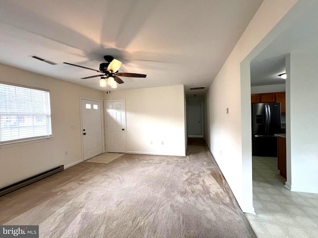 interior space featuring visible vents, baseboards, light colored carpet, and ceiling fan