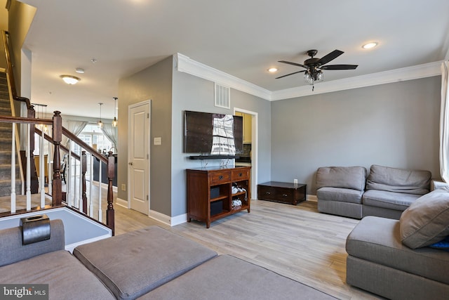 living room with visible vents, baseboards, stairway, ornamental molding, and light wood-style floors