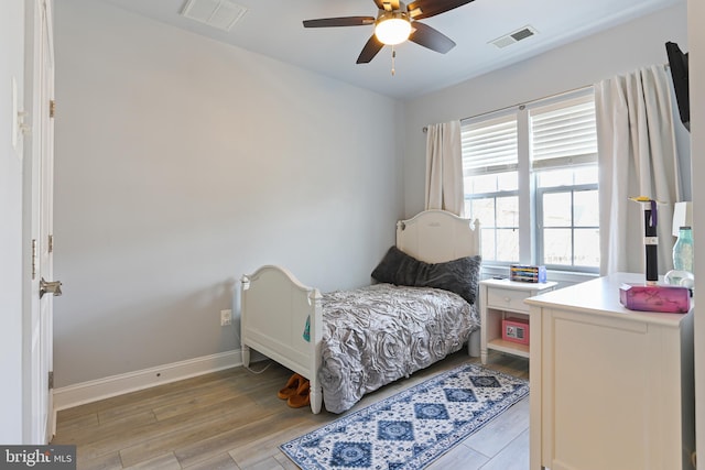 bedroom with visible vents, a ceiling fan, light wood-type flooring, and baseboards