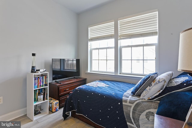 bedroom featuring baseboards and wood finished floors