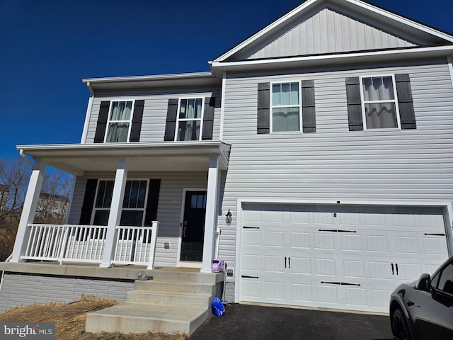 view of front of home with covered porch, driveway, and a garage