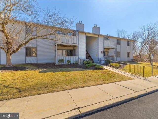 view of building exterior with a fenced front yard and central AC unit