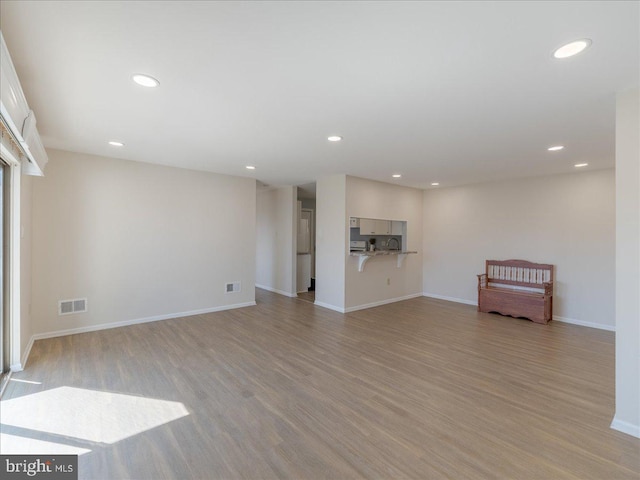 unfurnished living room with baseboards, recessed lighting, visible vents, and light wood-style floors