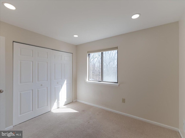 unfurnished bedroom featuring recessed lighting, a closet, carpet flooring, and baseboards