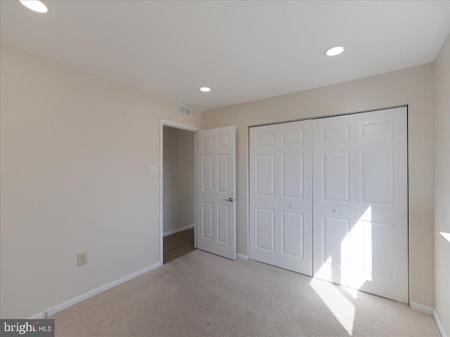 unfurnished bedroom featuring carpet, a closet, visible vents, and baseboards