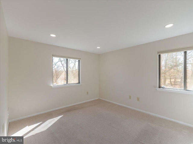 carpeted empty room featuring recessed lighting and baseboards