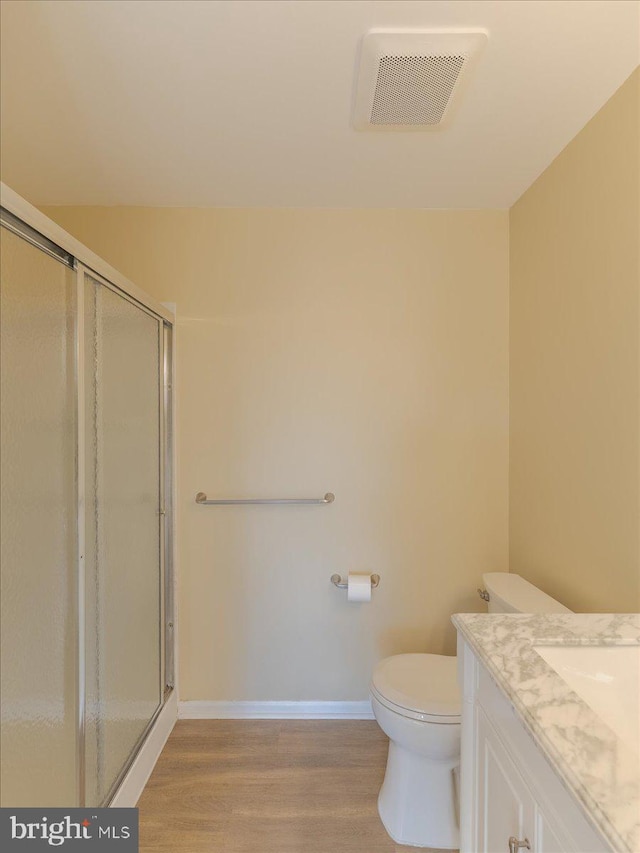 full bathroom with toilet, wood finished floors, a shower stall, and visible vents