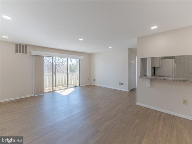 unfurnished living room featuring recessed lighting, visible vents, baseboards, and wood finished floors