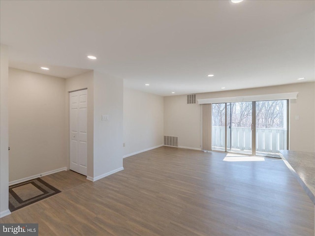 interior space featuring baseboards, wood finished floors, visible vents, and recessed lighting