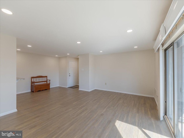 unfurnished room with baseboards, wood finished floors, and recessed lighting