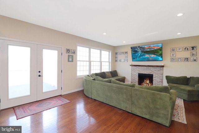 living room featuring wood finished floors, recessed lighting, french doors, a fireplace, and baseboards